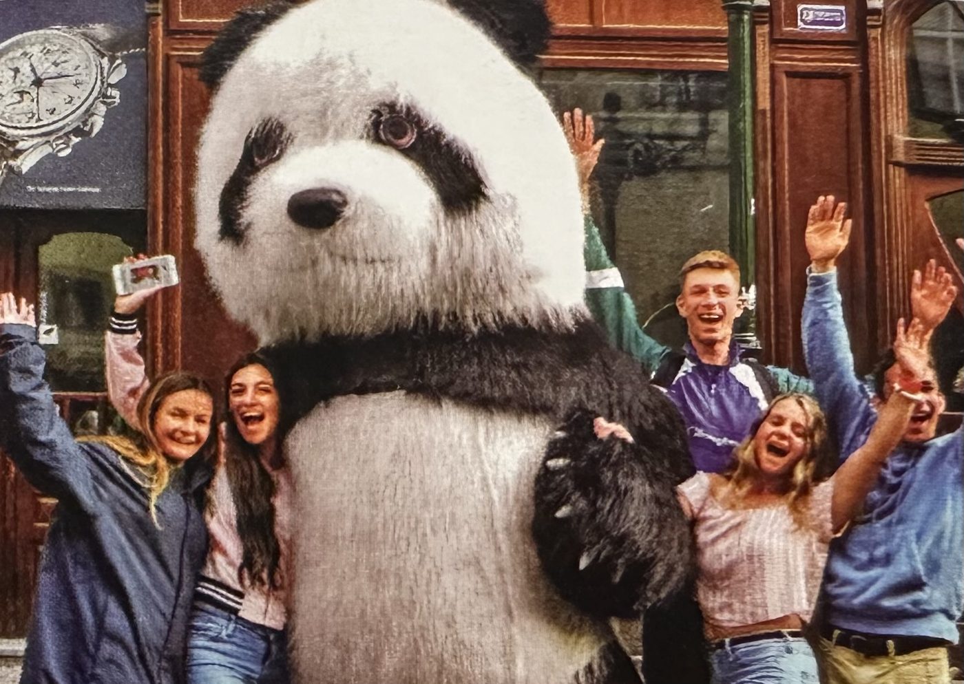 Players celebrating with a giant panda mascot